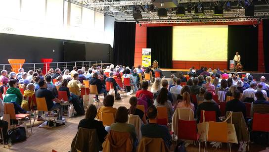 Tobias Böcker, Geschäftsführer der SRH Schulen GmbH, begrüßt auf der Bühne die Gäste in der großen Aula.