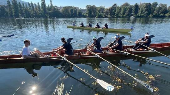 Ruderteam der SRH Schulen GmbH sitzt mit vier Ruderern und einem Steuermann im Ruderboot.