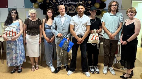 Gruppenbild der Absolvent:innen mit der Schulleiterin.